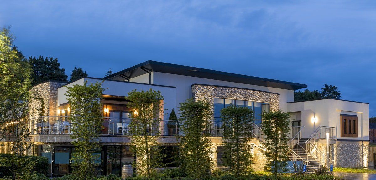 Modern apartment building with stone and glass facade lit up at dusk