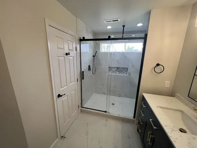 Bathroom remodel in Finksburg with walk-in shower, bench, rainfall showerhead, double vanity, picture window, and self-cleaning bidet