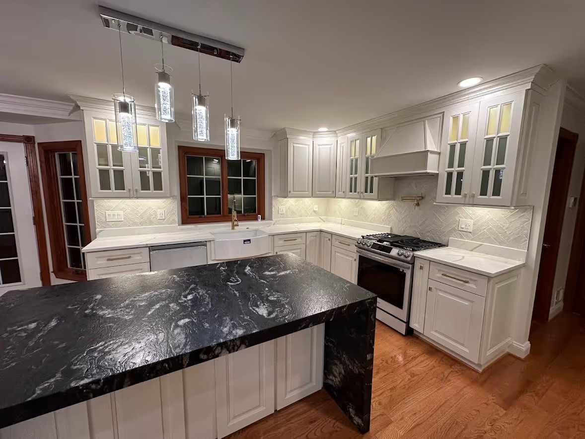 Modern kitchen with a high-gloss waterfall edge quartz countertop, integrated cabinet lighting