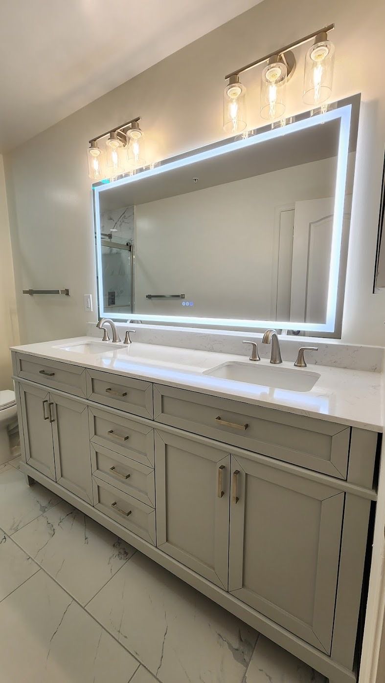 Bathroom in Sykesville with double vanity, marble-look tile floor, brushed nickel fixtures, LED mirror, and Bluetooth exhaust fan