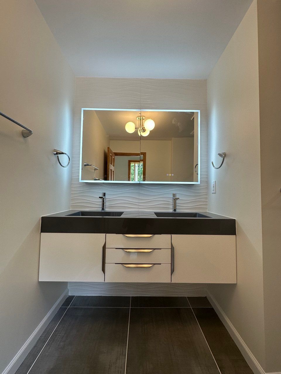 Expanded master bathroom in Finksburg with floating double vanity, LED mirror, large shower, bidet toilet, and 24x24 tile flooring