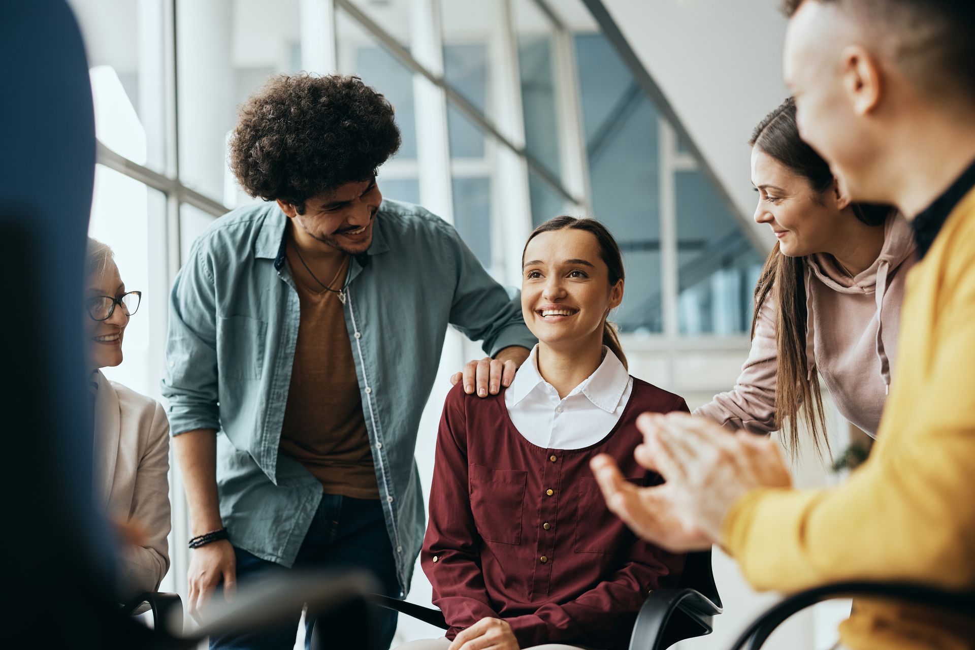 Group of people gathered around a woman, smiling and celebrating. Group of people gathered around a woman, smiling and celebrating.