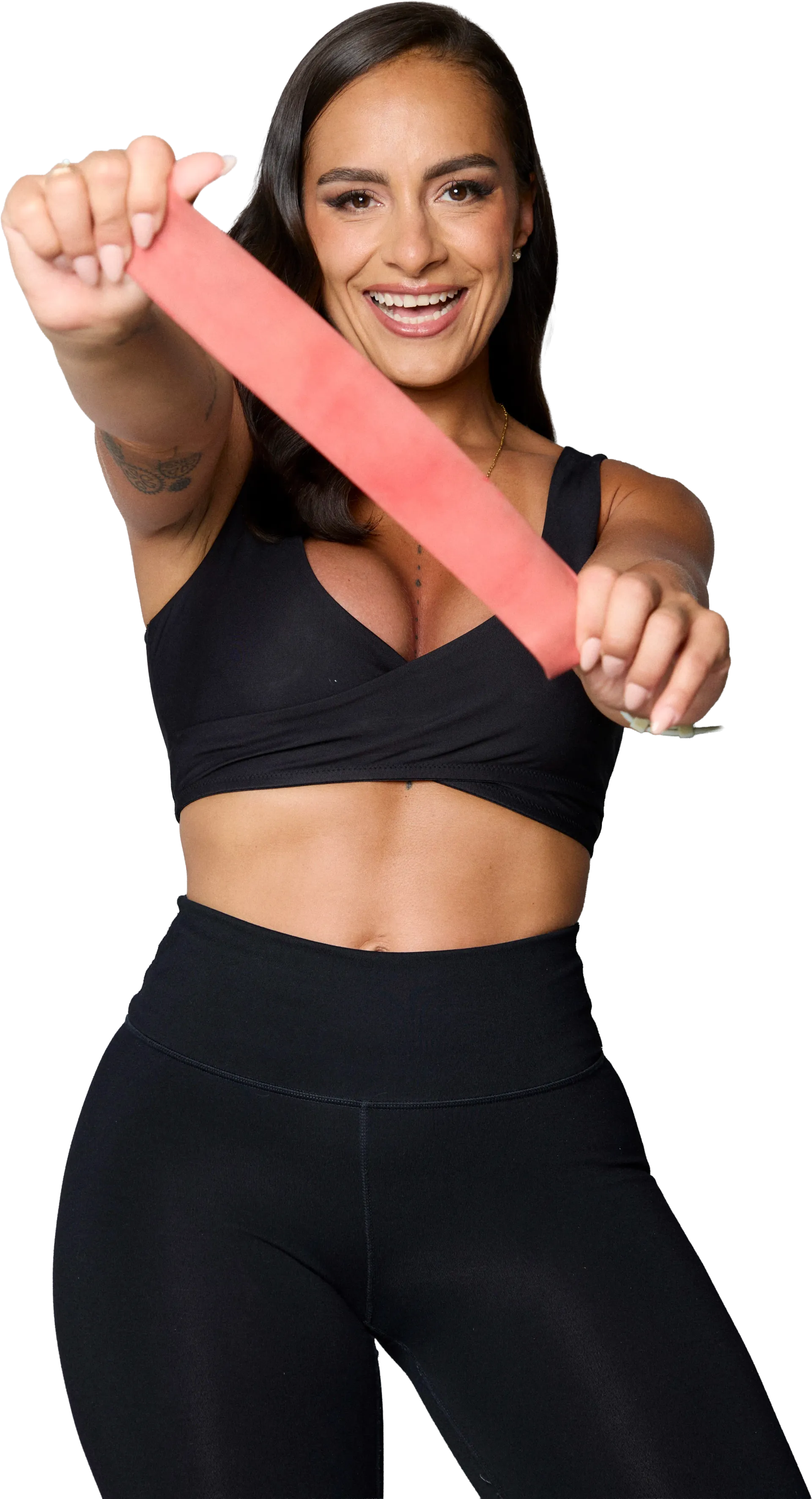 Woman in black workout clothes stretching a pink resistance band against a white background