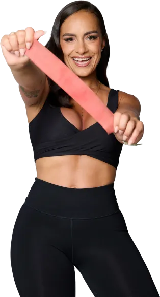 Woman in black workout clothes stretching a pink resistance band against a white background