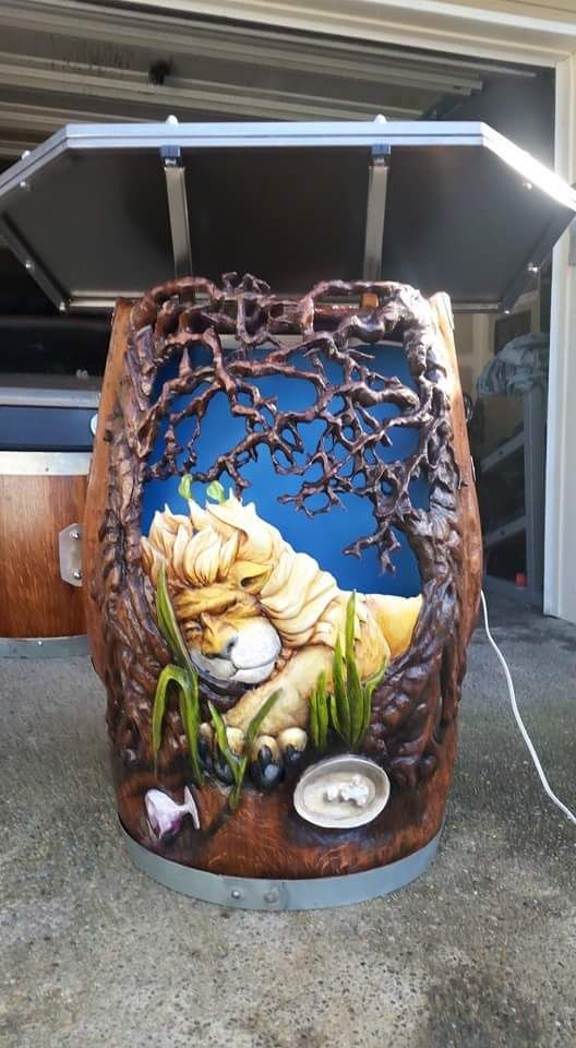 Decorated metal barrel with a blue sky mural, twisting vines, mushrooms, and a painted gnome in a garden scene
