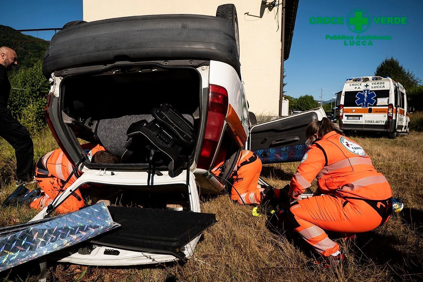 Volontari protezione civile mentre fanno uscire delle persone da un'auto ribaltata