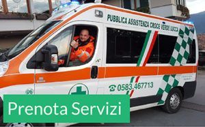 Ambulanza con strisce arancioni e dettagli verdi, operatore sanitario di emergenza visibile al posto di guida, striscione "Prenota Servizi".