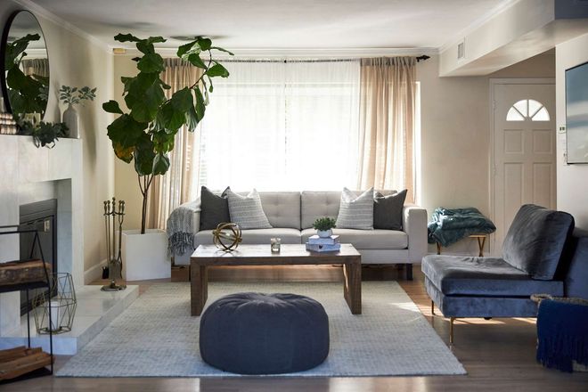 A living room with a couch , chairs , coffee table and fireplace.