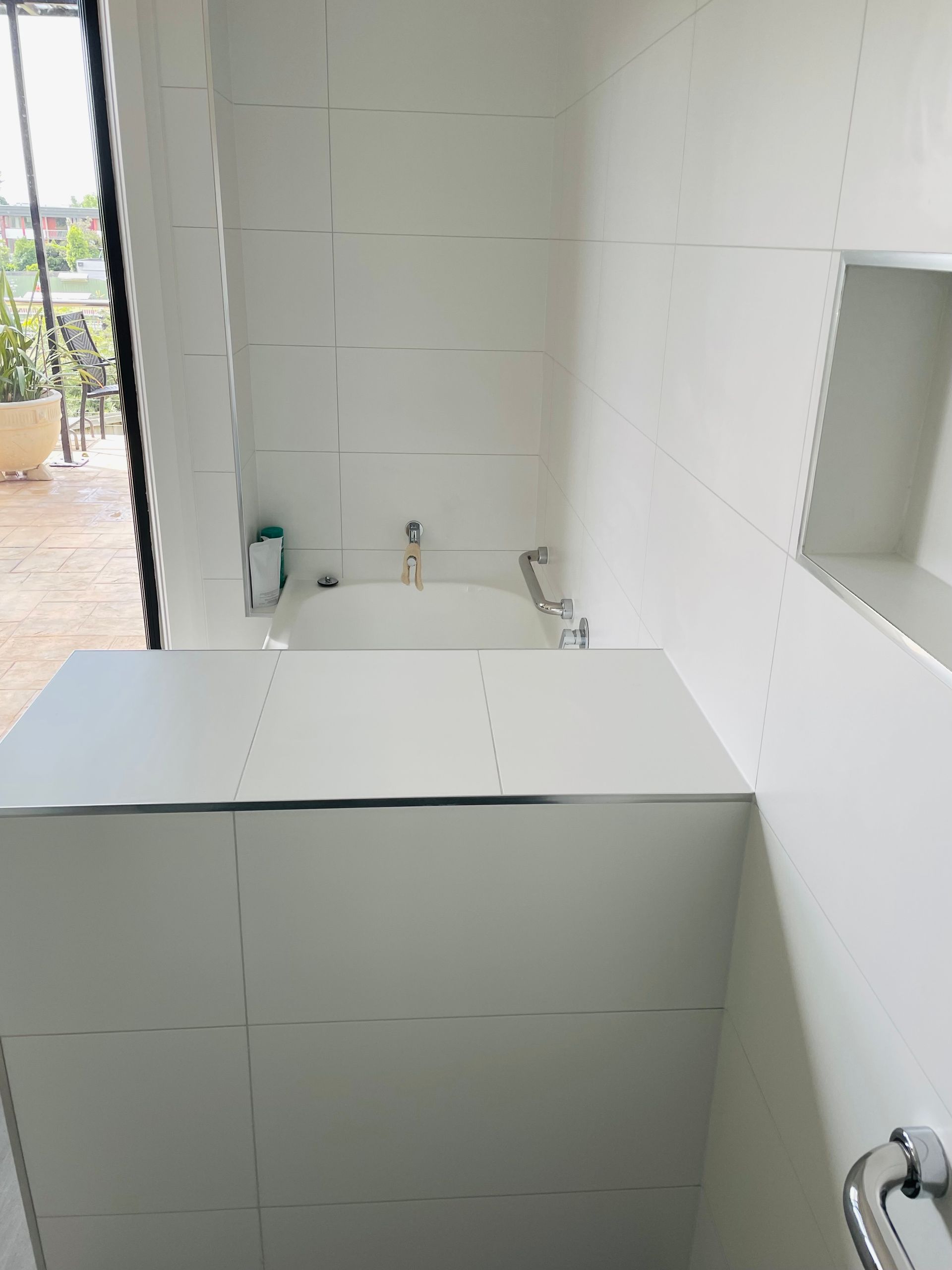 A White, Tiled Bathroom Wall Features a Built-in Shelf — Hobart Tiling Solutions In Clarendon Vale, TAS