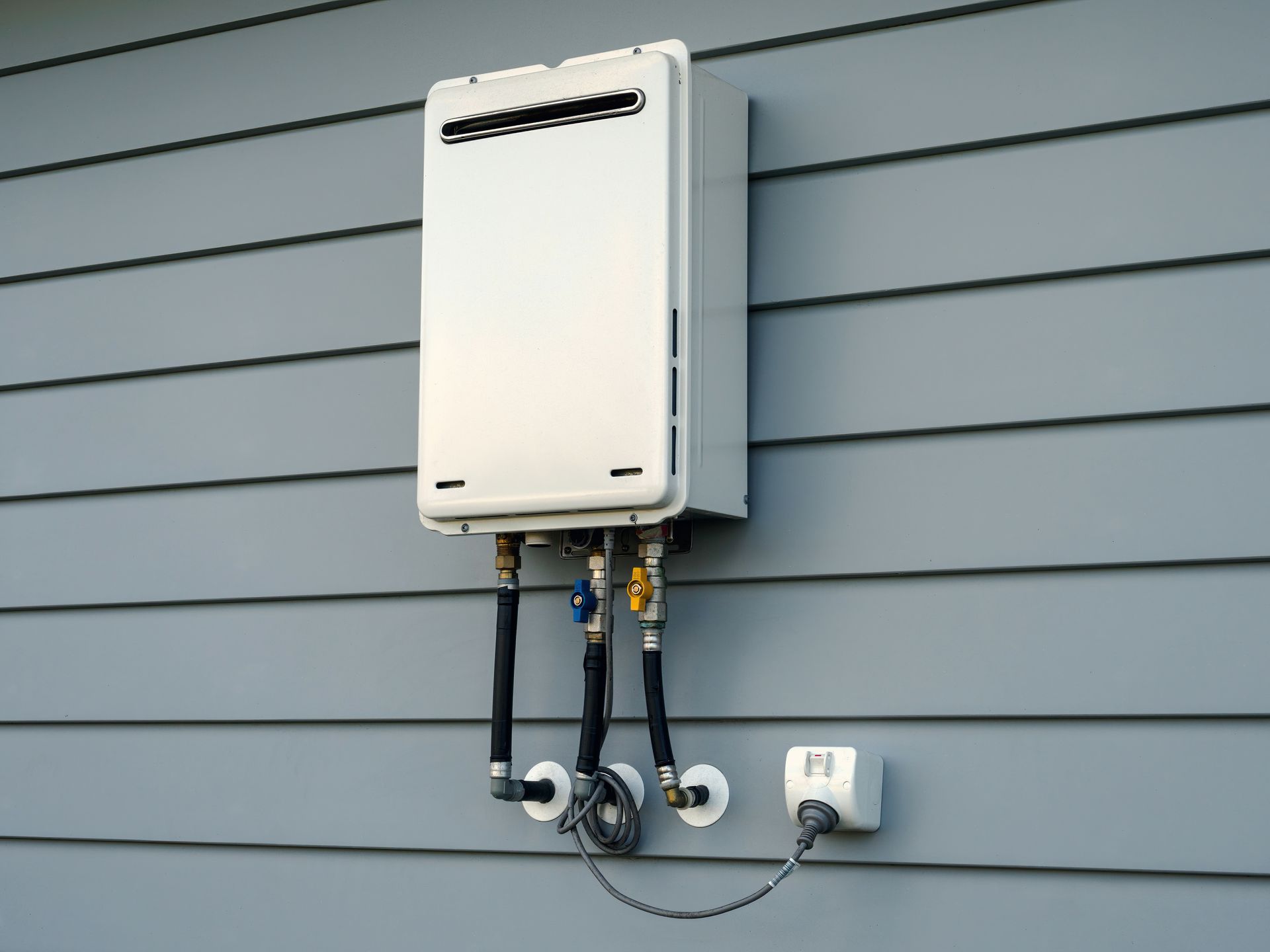 Modern external continuous flow gas water heater mounted on house exterior