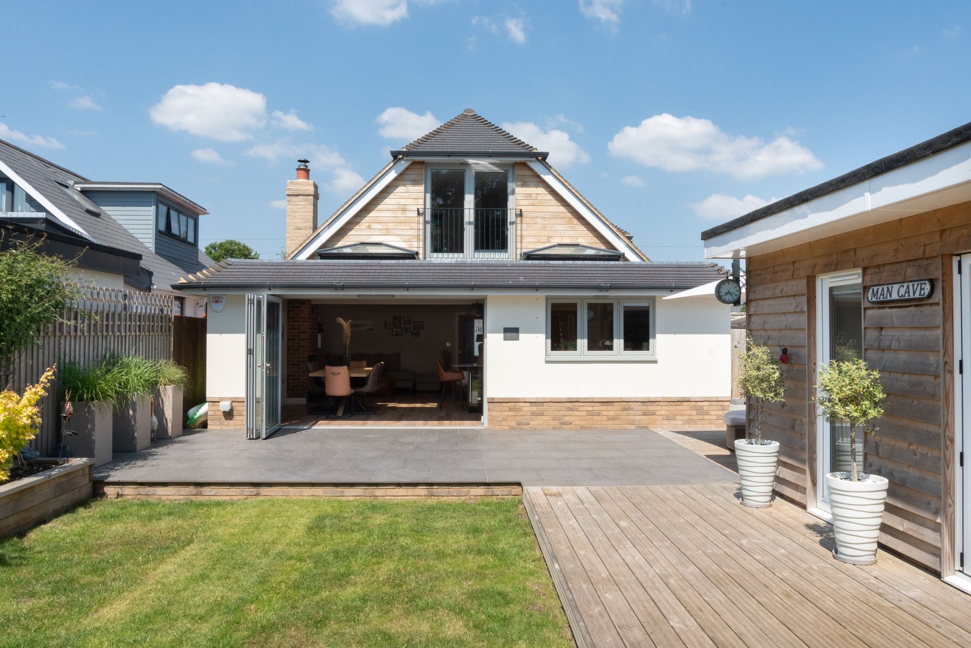 The back of a house with a large patio in front of it.