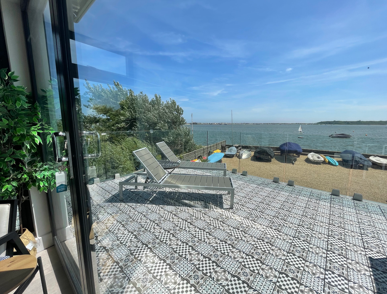 A patio with lawn chairs and a view of the ocean.