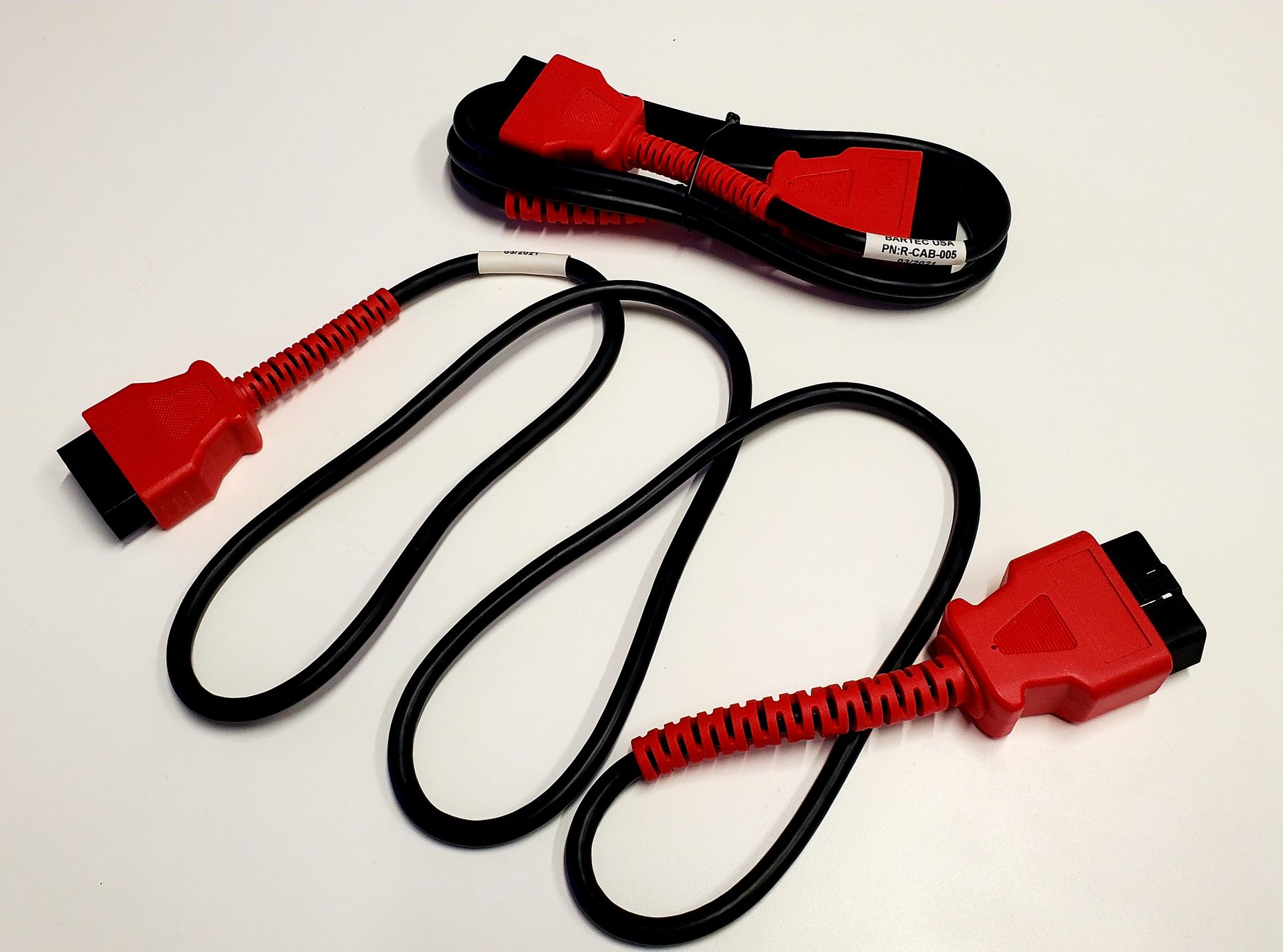 A pair of red and black cables on a white surface