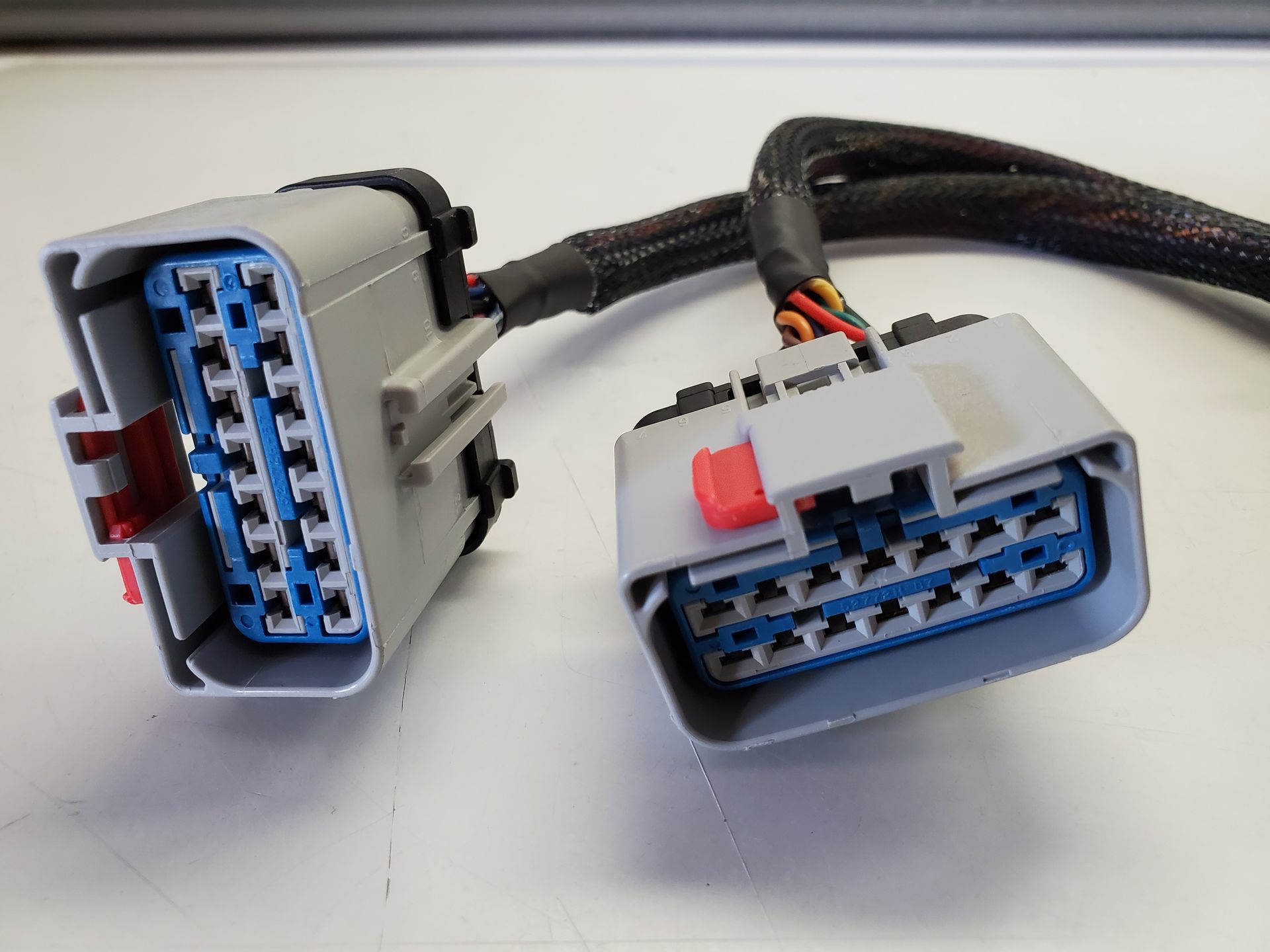 A close up of two electrical connectors on a white surface