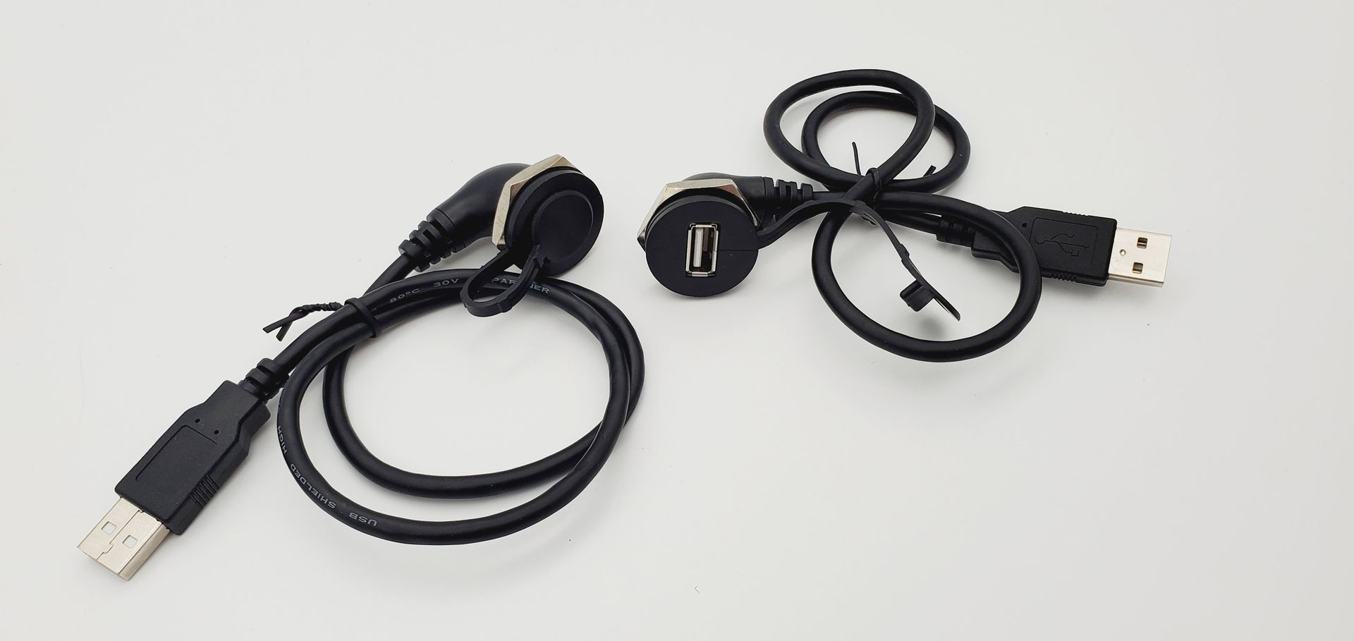 Two usb cables are sitting on a white surface.