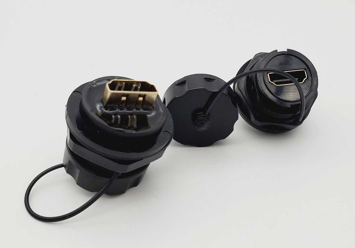 Three black connectors with a cord attached to them on a white surface.