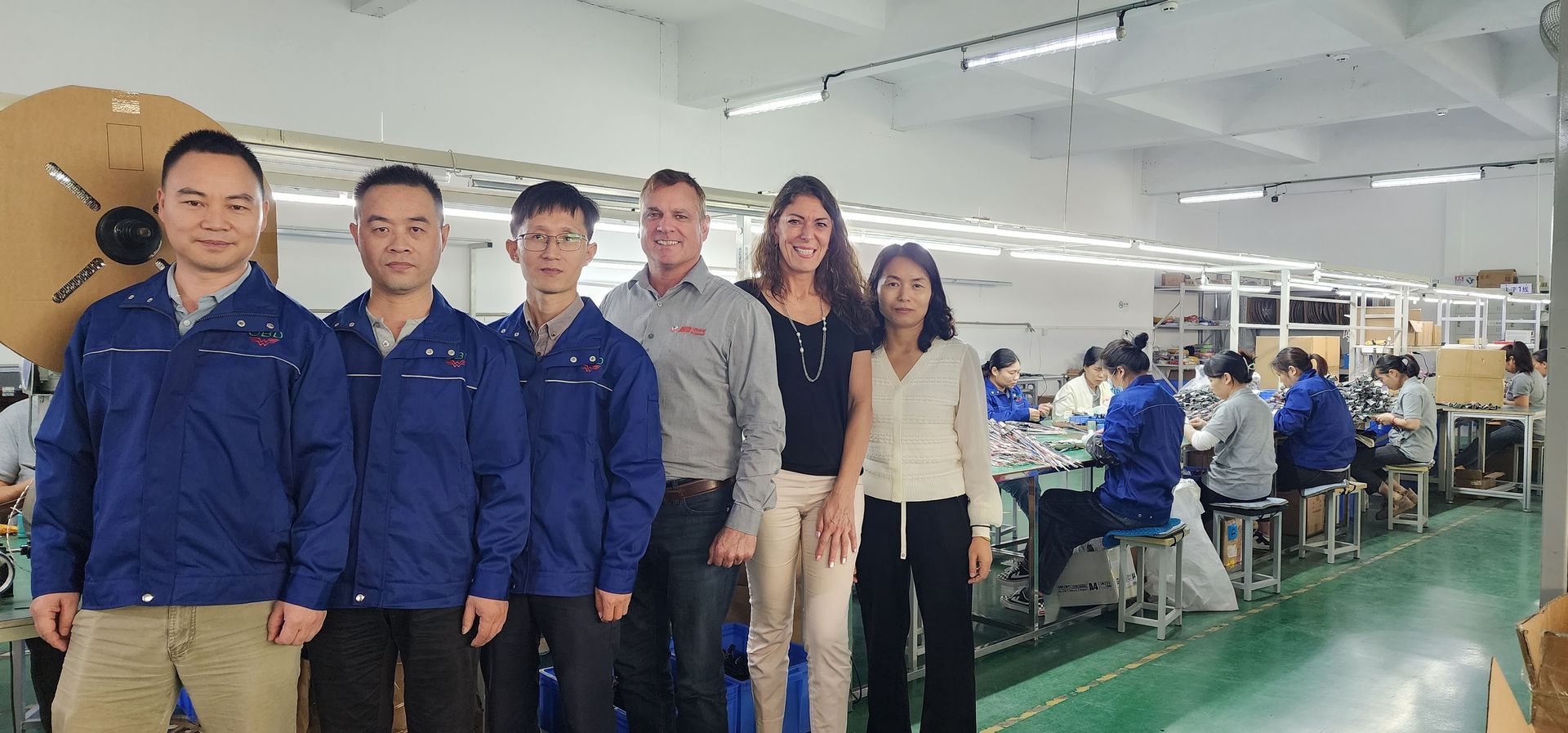 A group of people are posing for a picture in a factory.