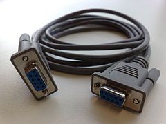 A close up of a rs232 cable on a table.
