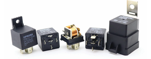 Assorted black electrical relays and a small relay module on a white background.