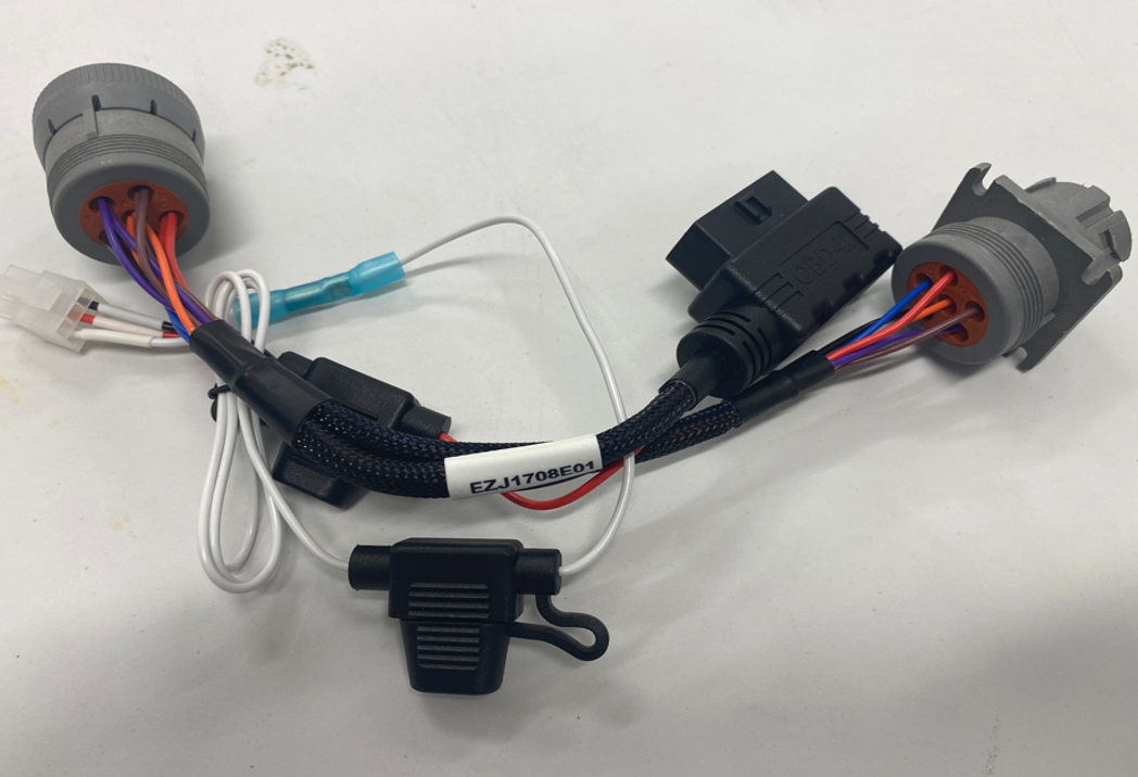 Wiring harness with several connectors and a small black clip on a white background