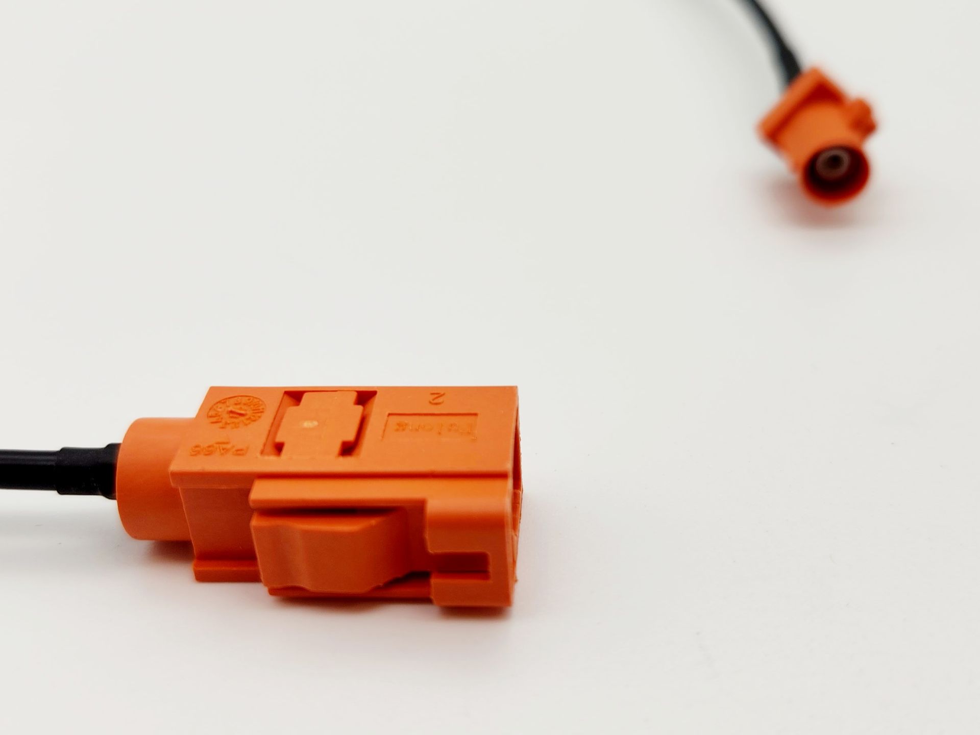 A close up of an orange connector on a white surface