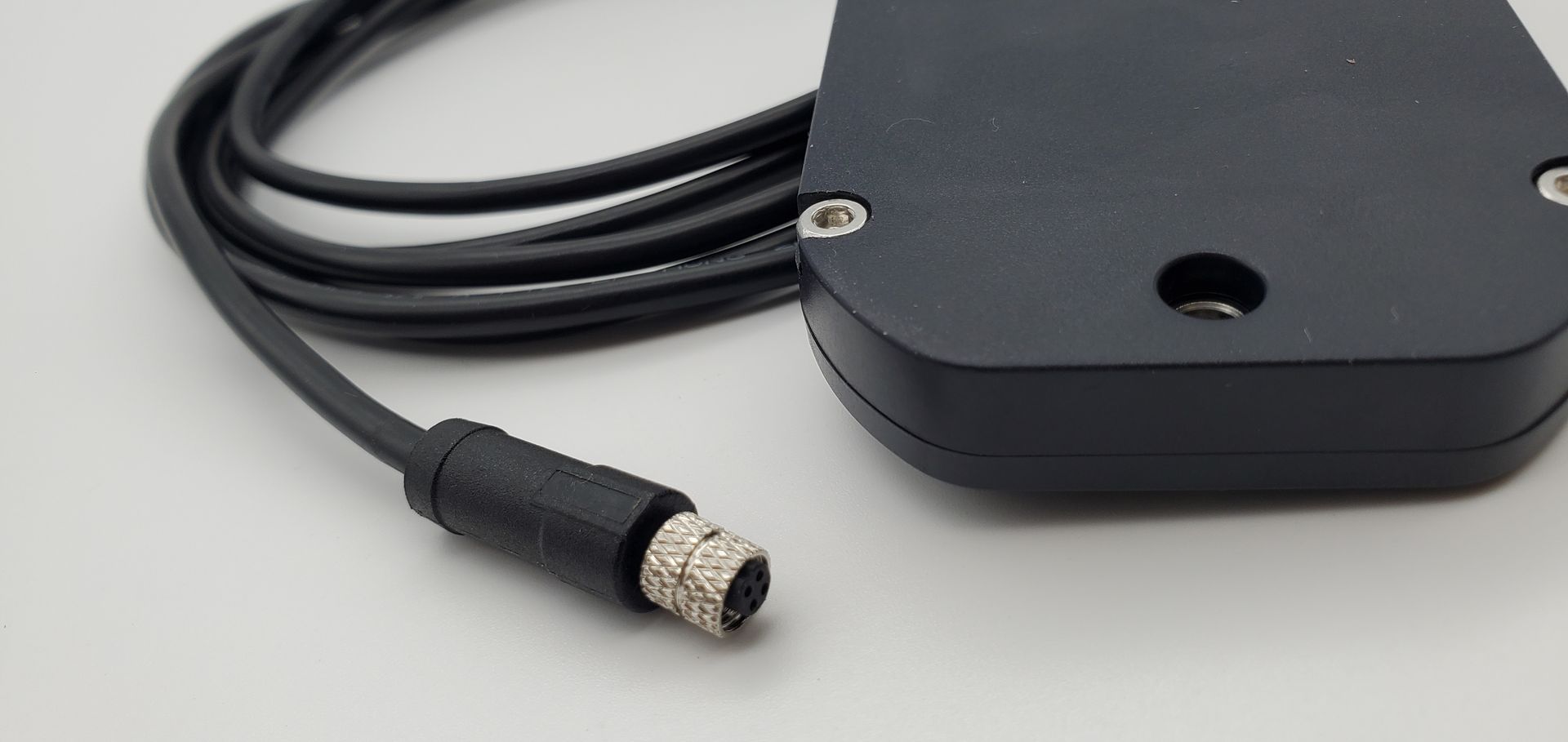A close up of a black cable connected to a black device.