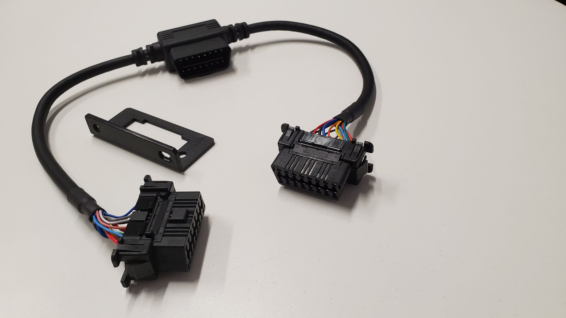 A black cable with connectors attached to it is sitting on a white table.