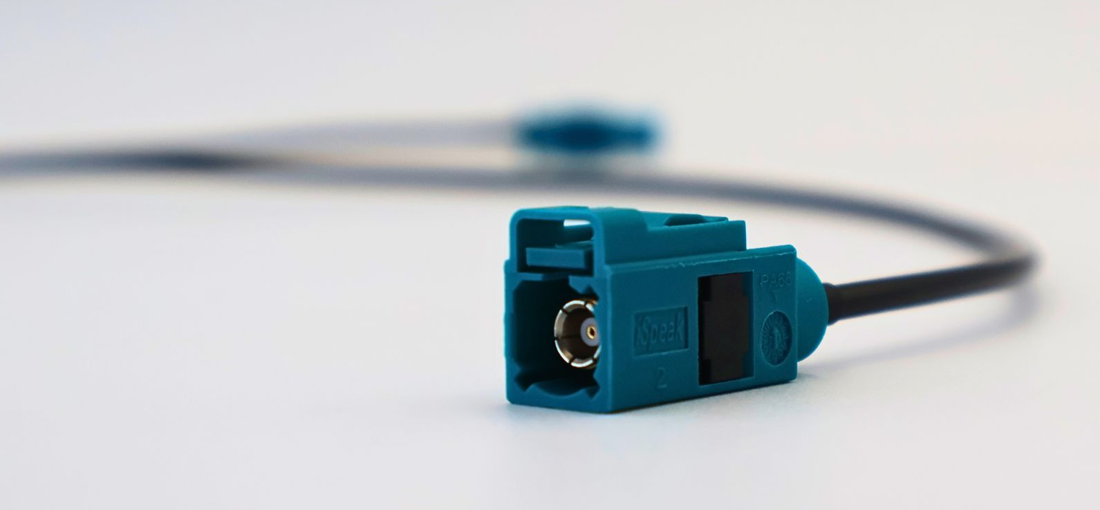 Blue fiber optic connector on a black cable against a white background