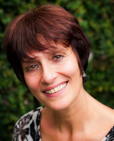 A woman with short brown hair is smiling for the camera.