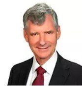 A man in a suit and tie is smiling for the camera.