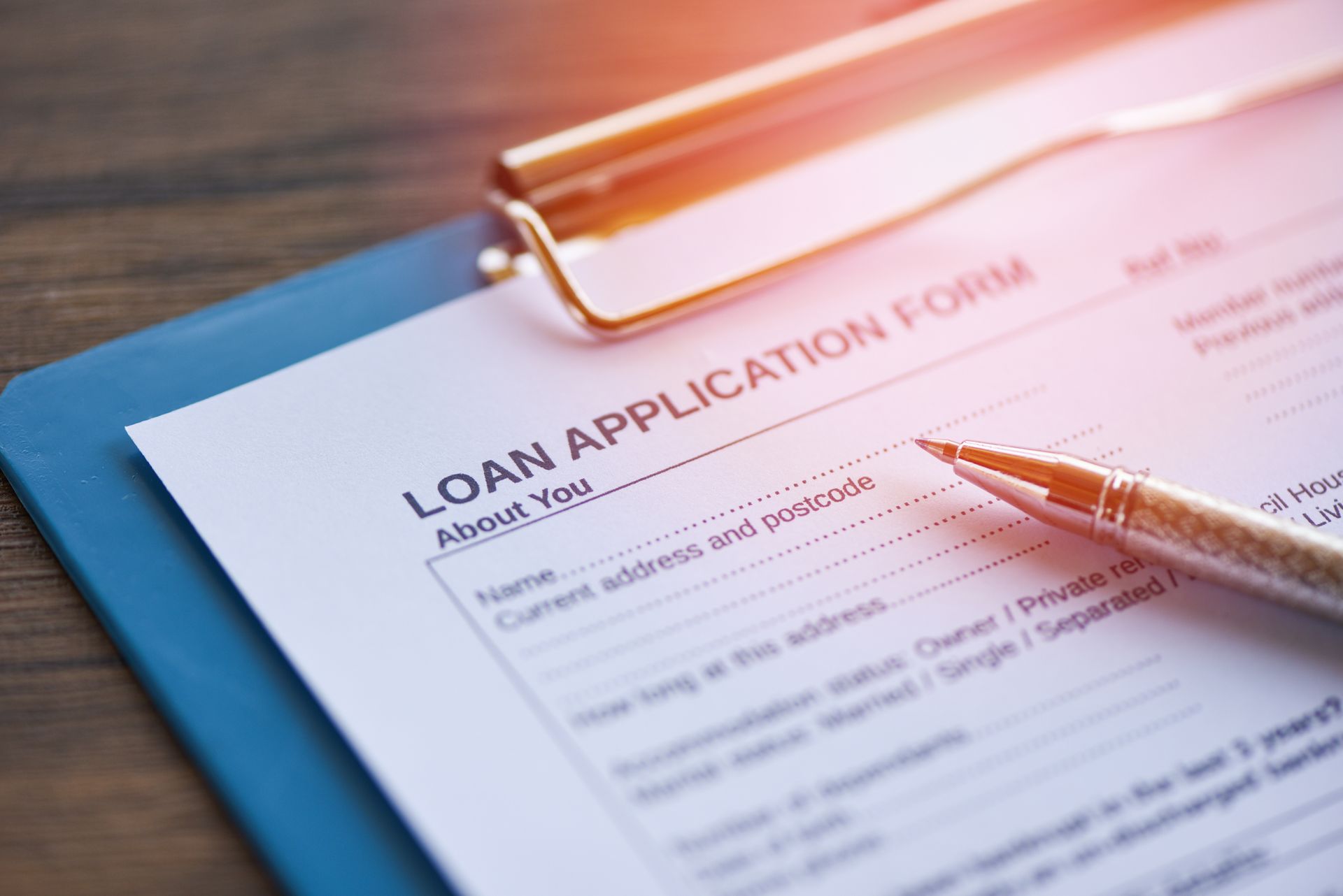Close-up of a loan application form on a clipboard with a pen resting on top.