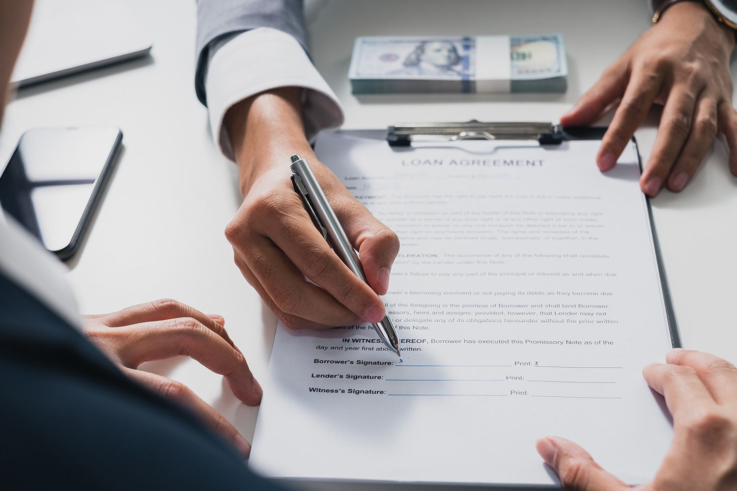 Businessman sign on money loan agreement contract to banker. Businessman sign on money loan agreement contract to banker.