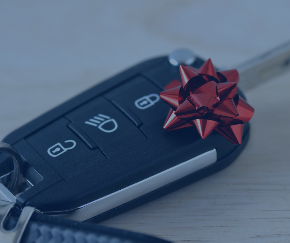 A car key with a red bow on it