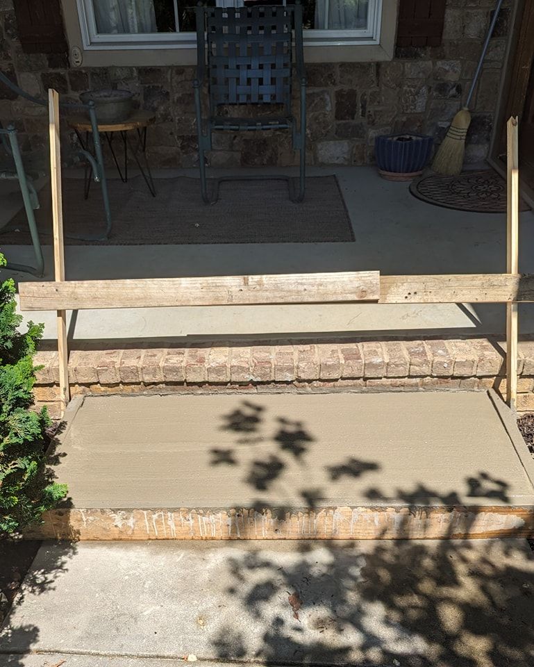 A concrete walkway is being built in front of a brick building.
