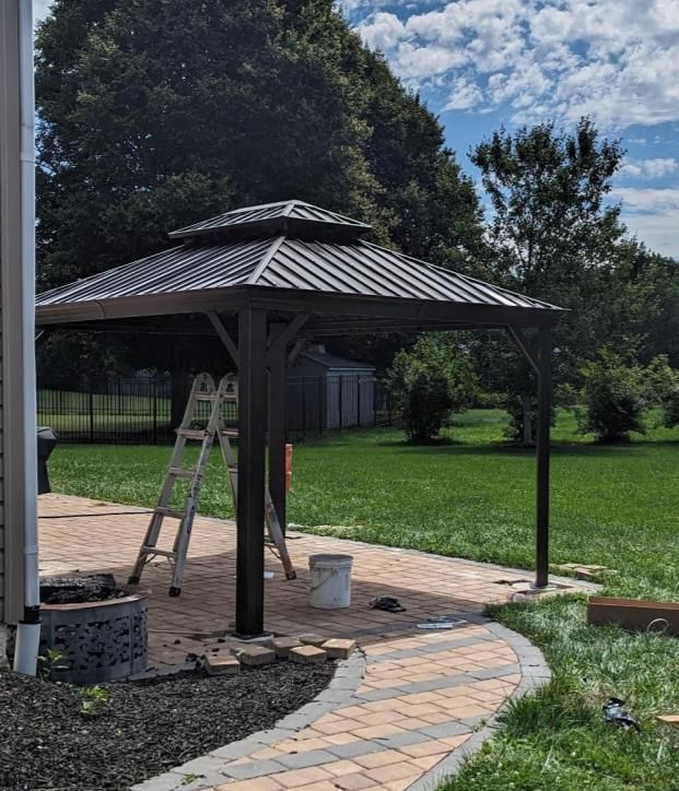 A gazebo is being built in the backyard of a house
