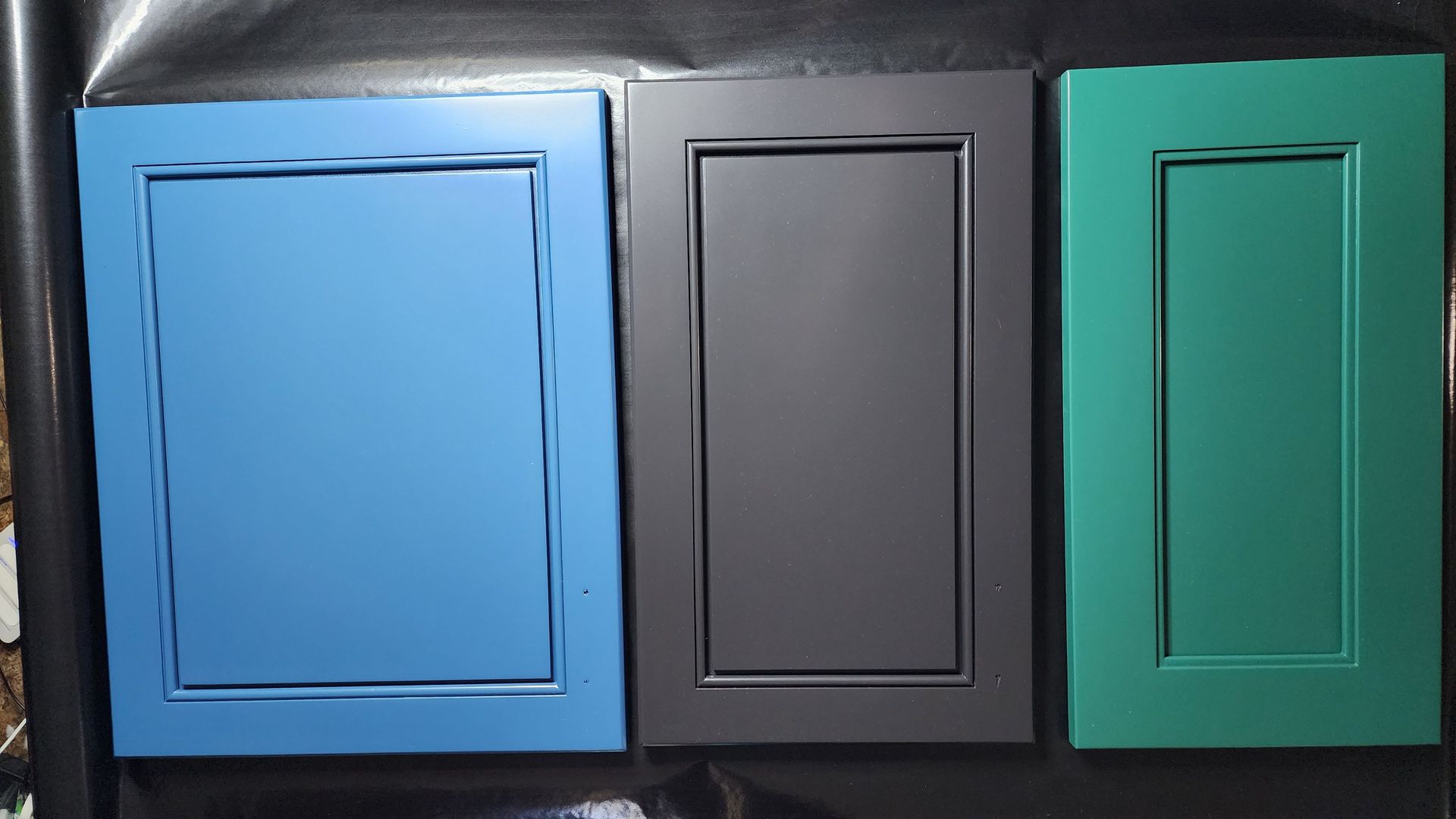 Three colored wall panels: blue, dark gray, and teal, each with a raised rectangular inset.
