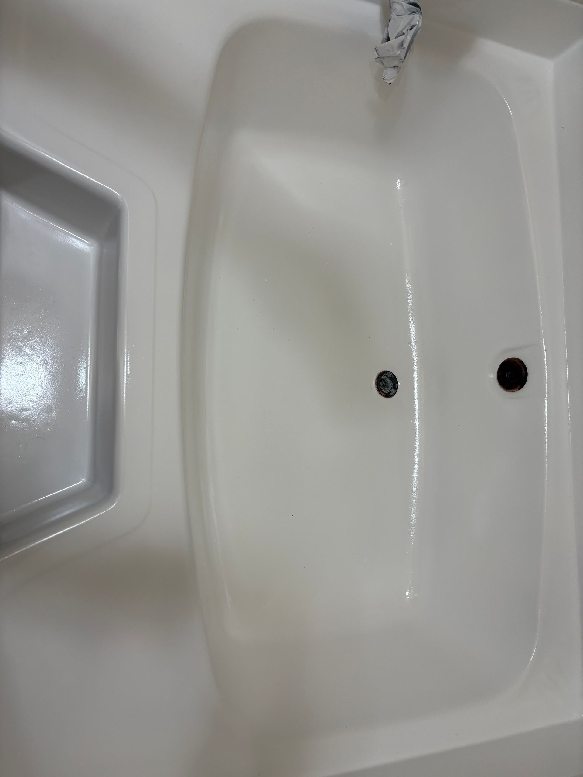 White bathroom sink with running water and two drain holes