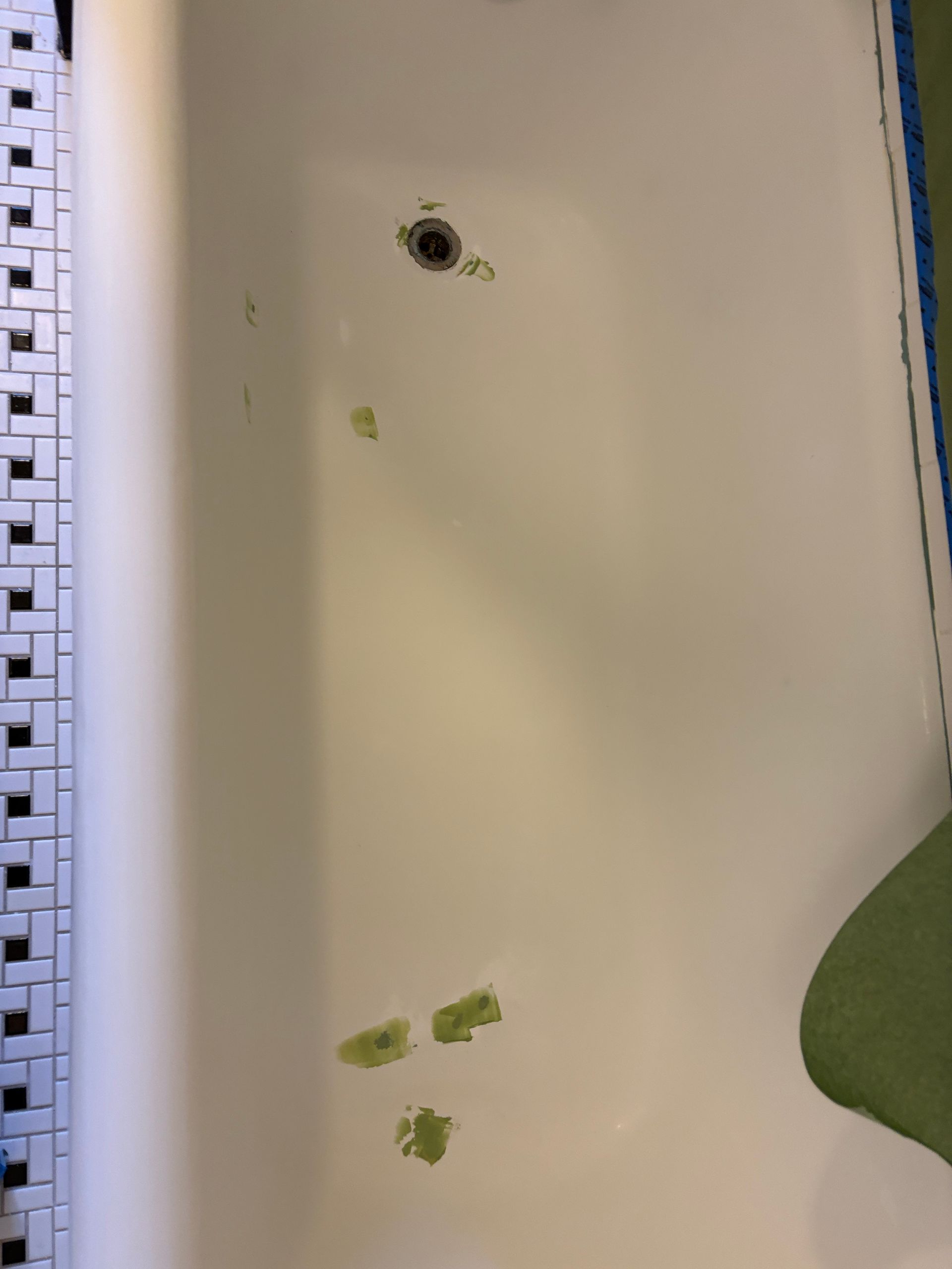 White notebook page with a hole punch and a few small green paint or ink smudges