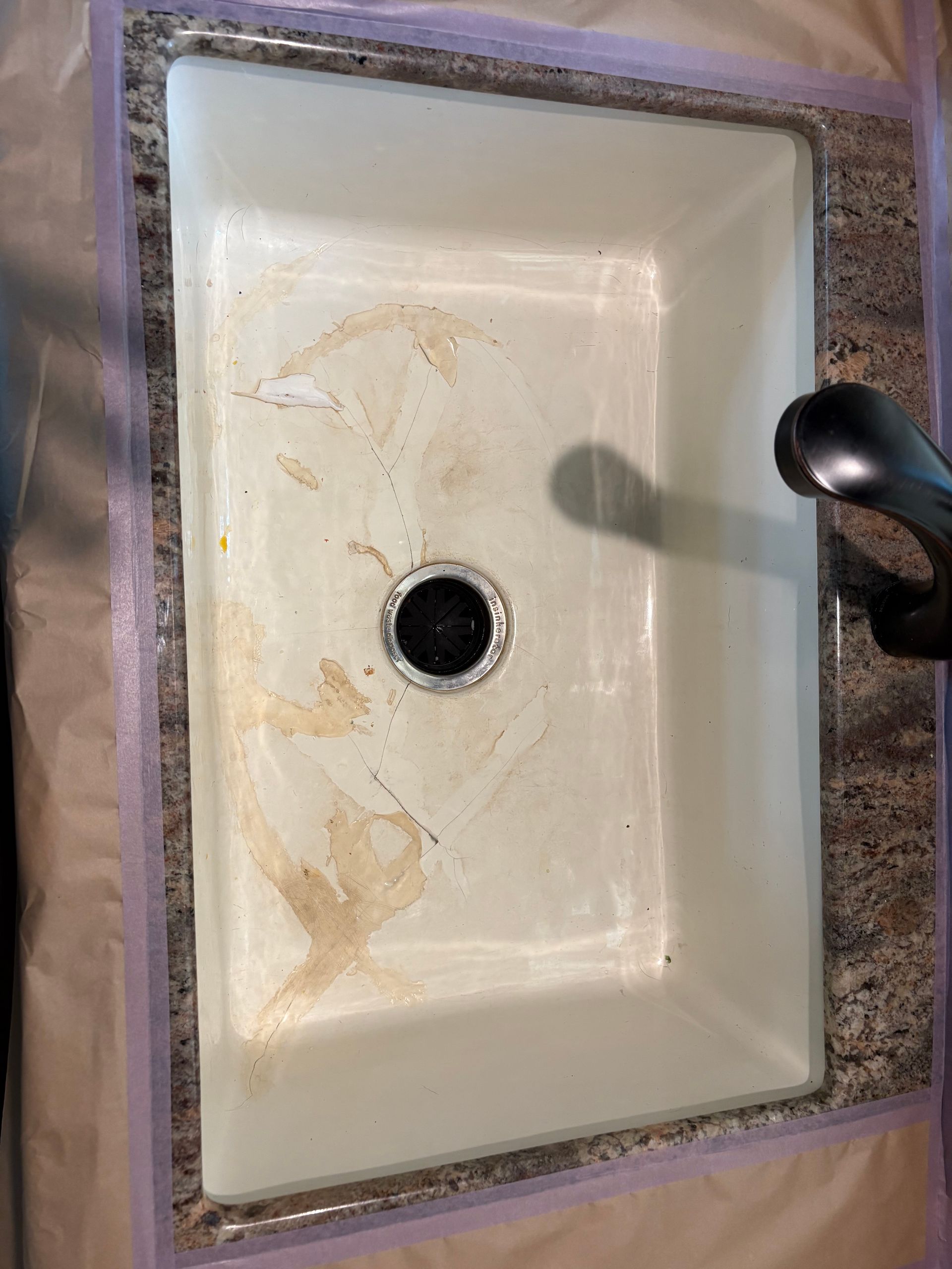 Dirty white bathroom sink with black faucet and stained basin