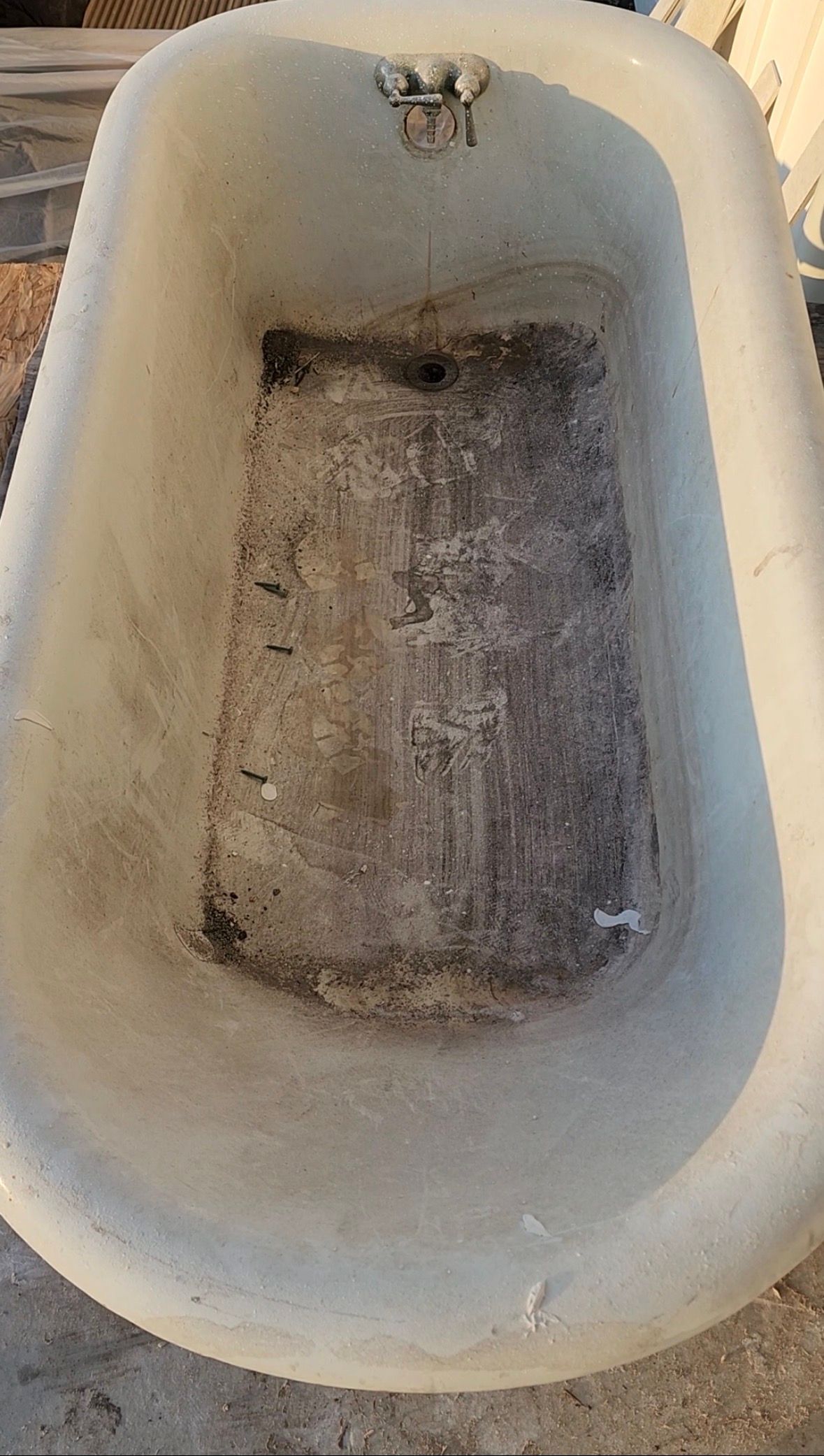 Dirty empty bathtub with grime and stains inside