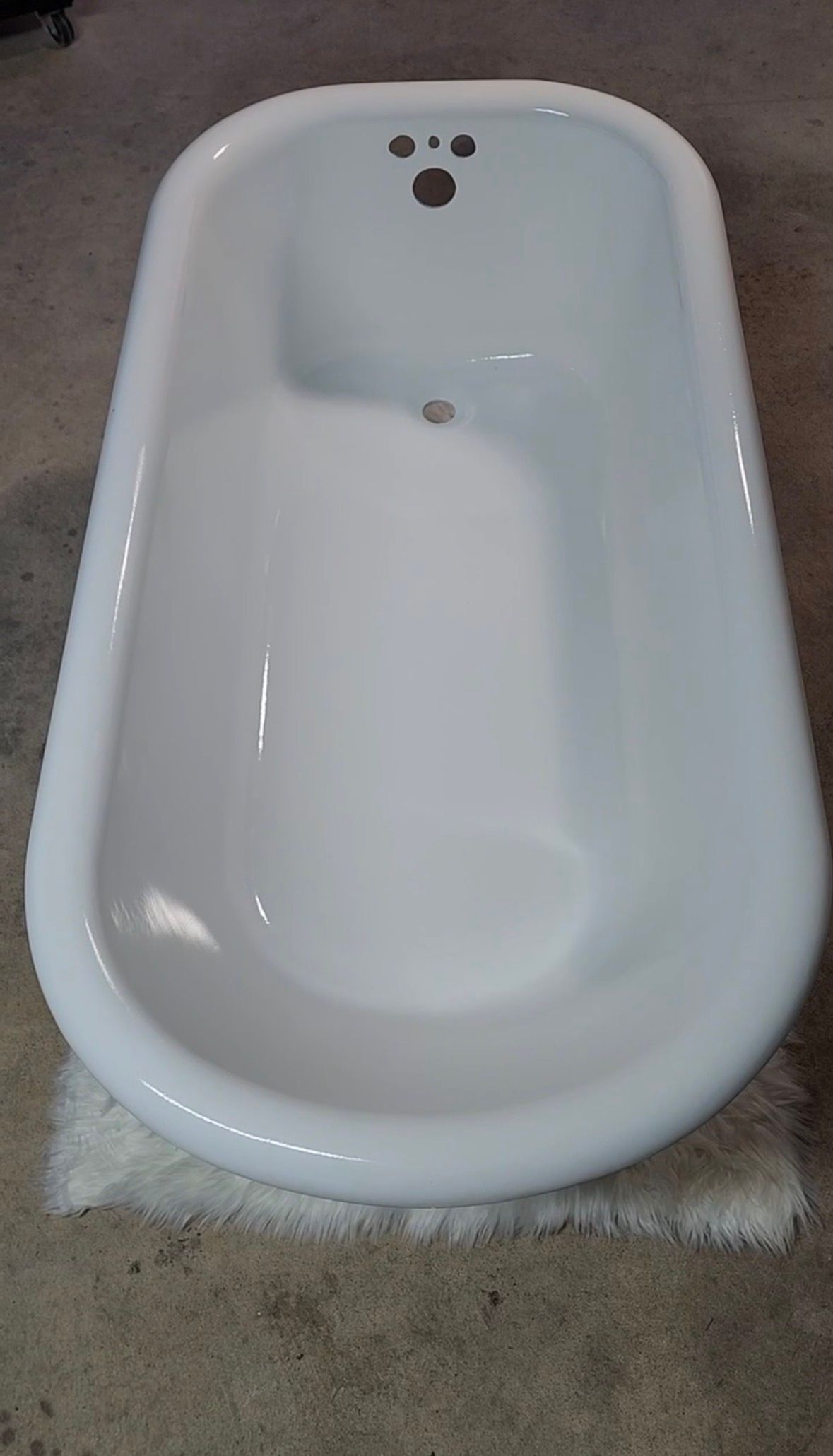 White baby bathtub viewed from above on a carpeted floor.