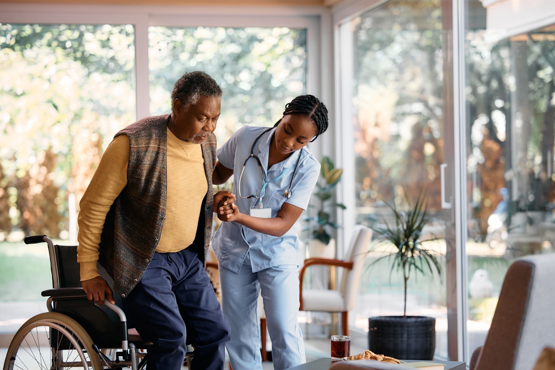 nurse helping old lady from chair