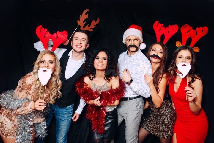 Group in holiday attire and reindeer antlers at a Christmas party.