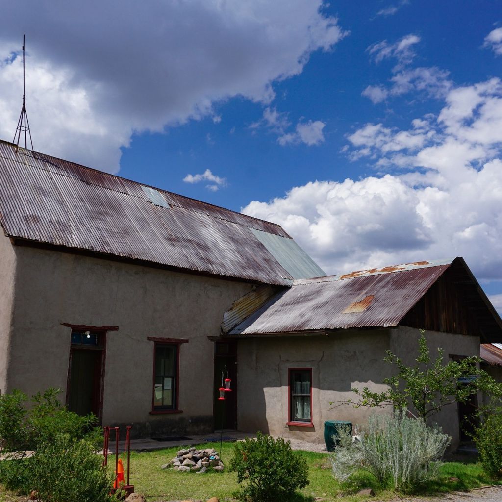 A small house with a roof that has a weather vane on top of it