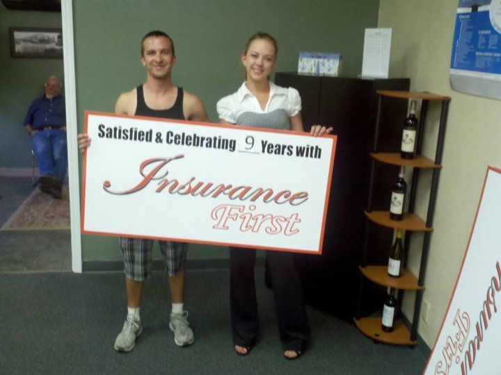 A man and a woman holding a sign that says Insurance First