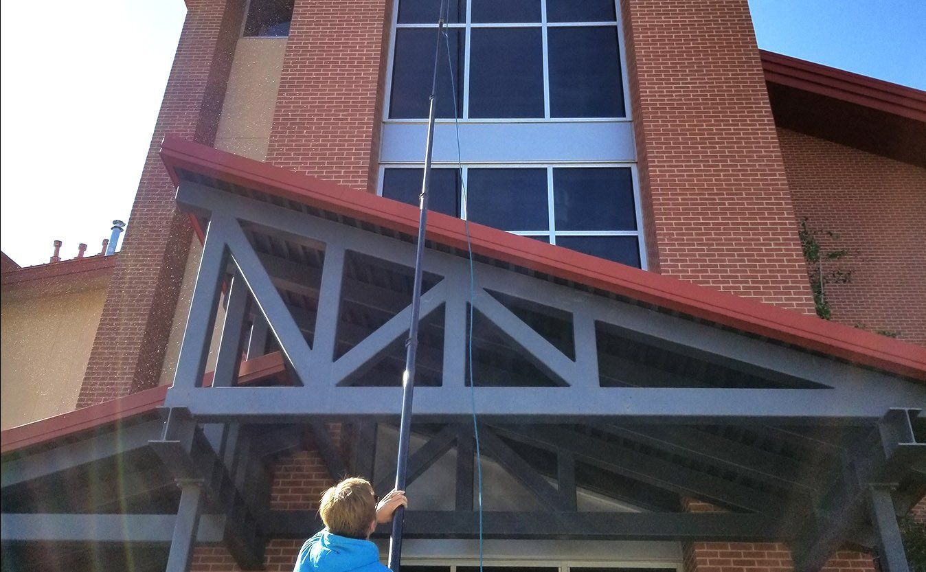 man using water fed pole to clean
