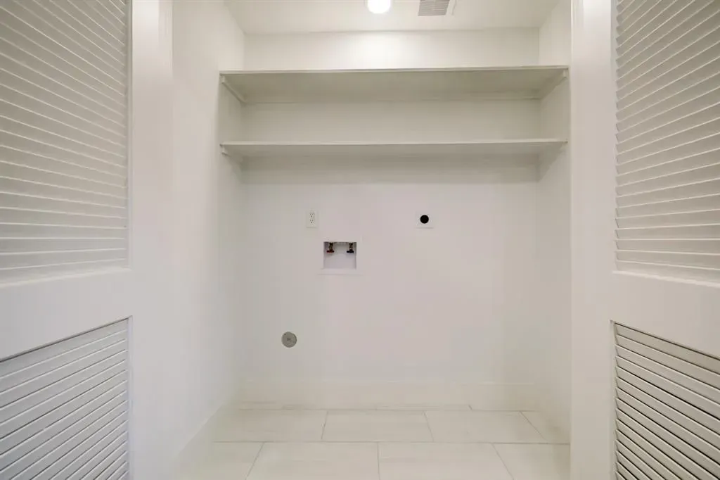 Empty white built-in closet with shelves, drawers, and louvered side panels.