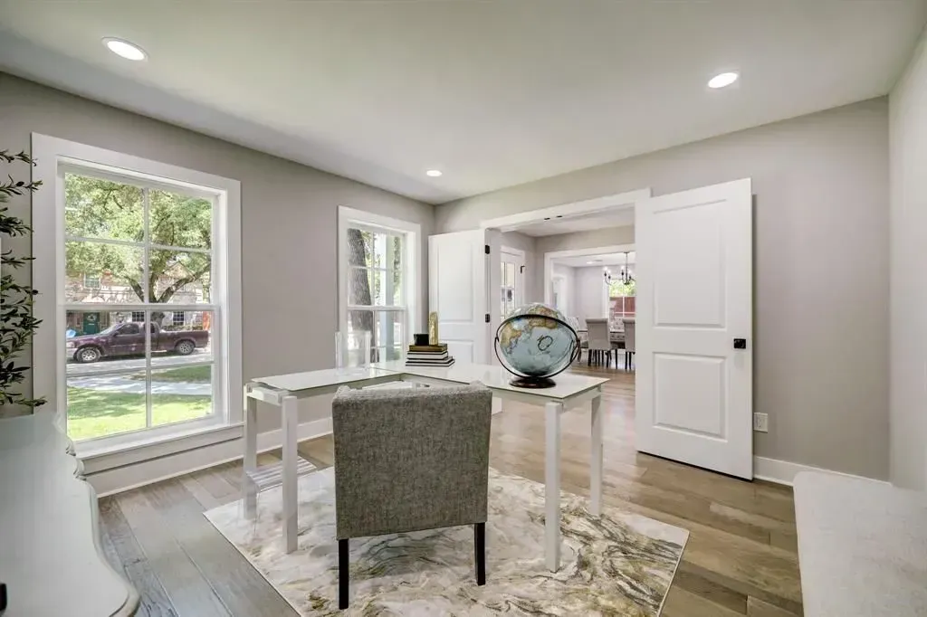 Bright dining room with white table, gray chairs, large windows, and light wood floors