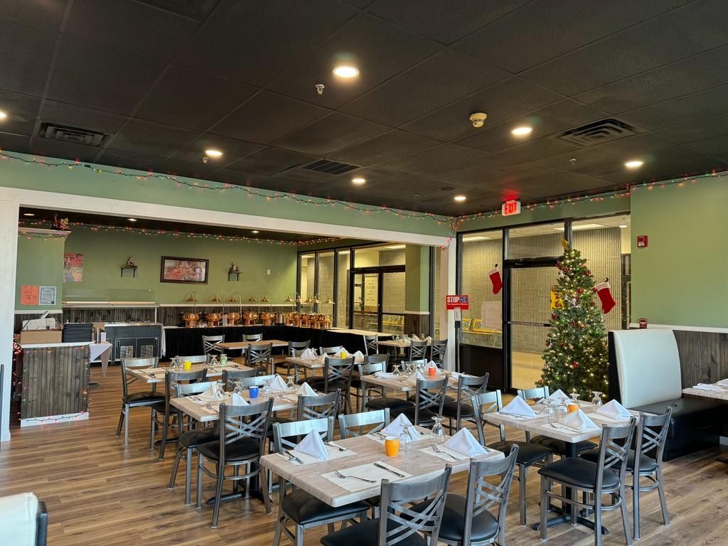 Restaurant interior with tables set for dining, Christmas decorations, and a black ceiling.