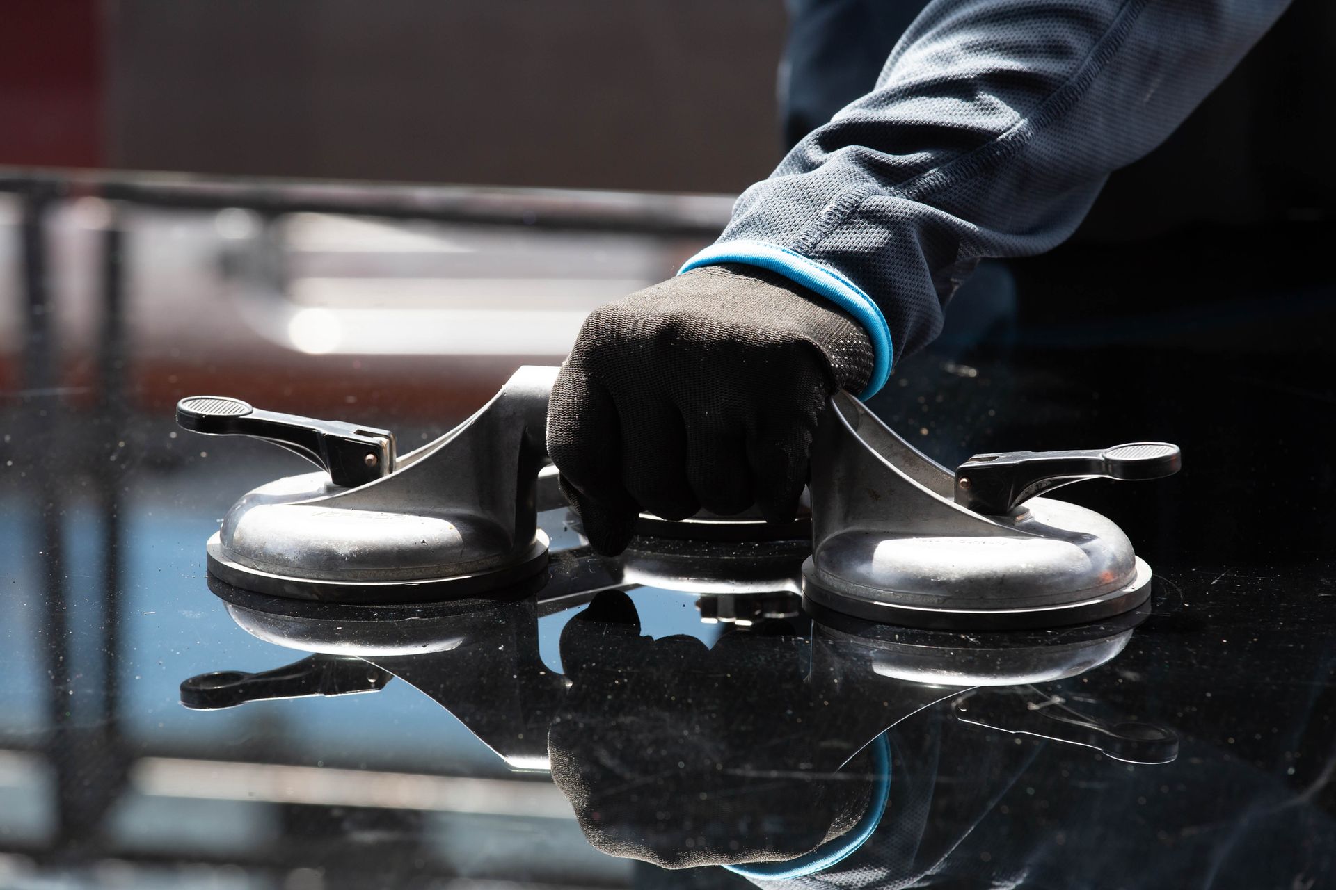 A person is fixing a windshield on a car.